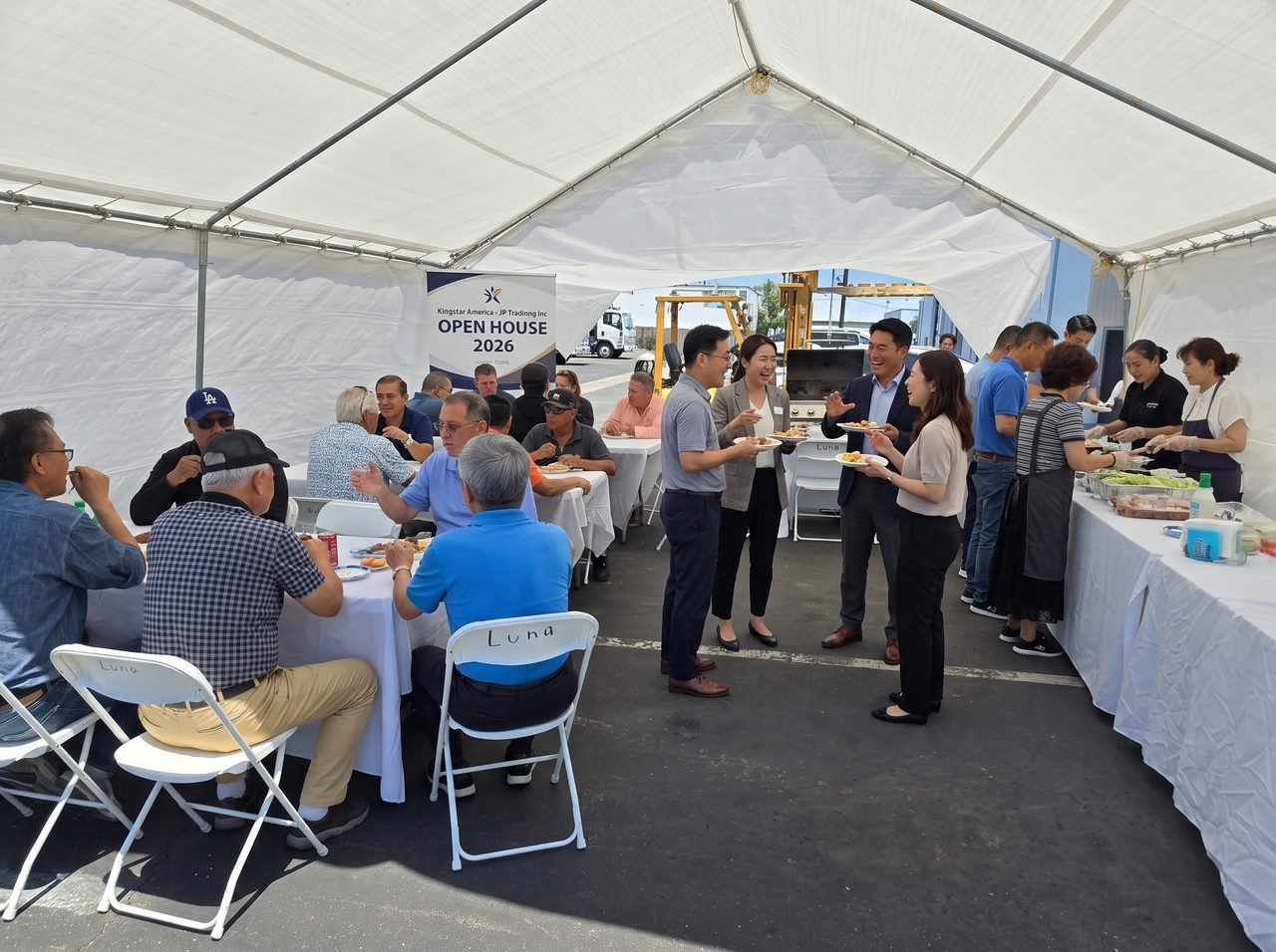 Customers and the Kingstar America team sharing lunch under the marquee at the Kingstar America and JP Trading Inc. Open House 2026.