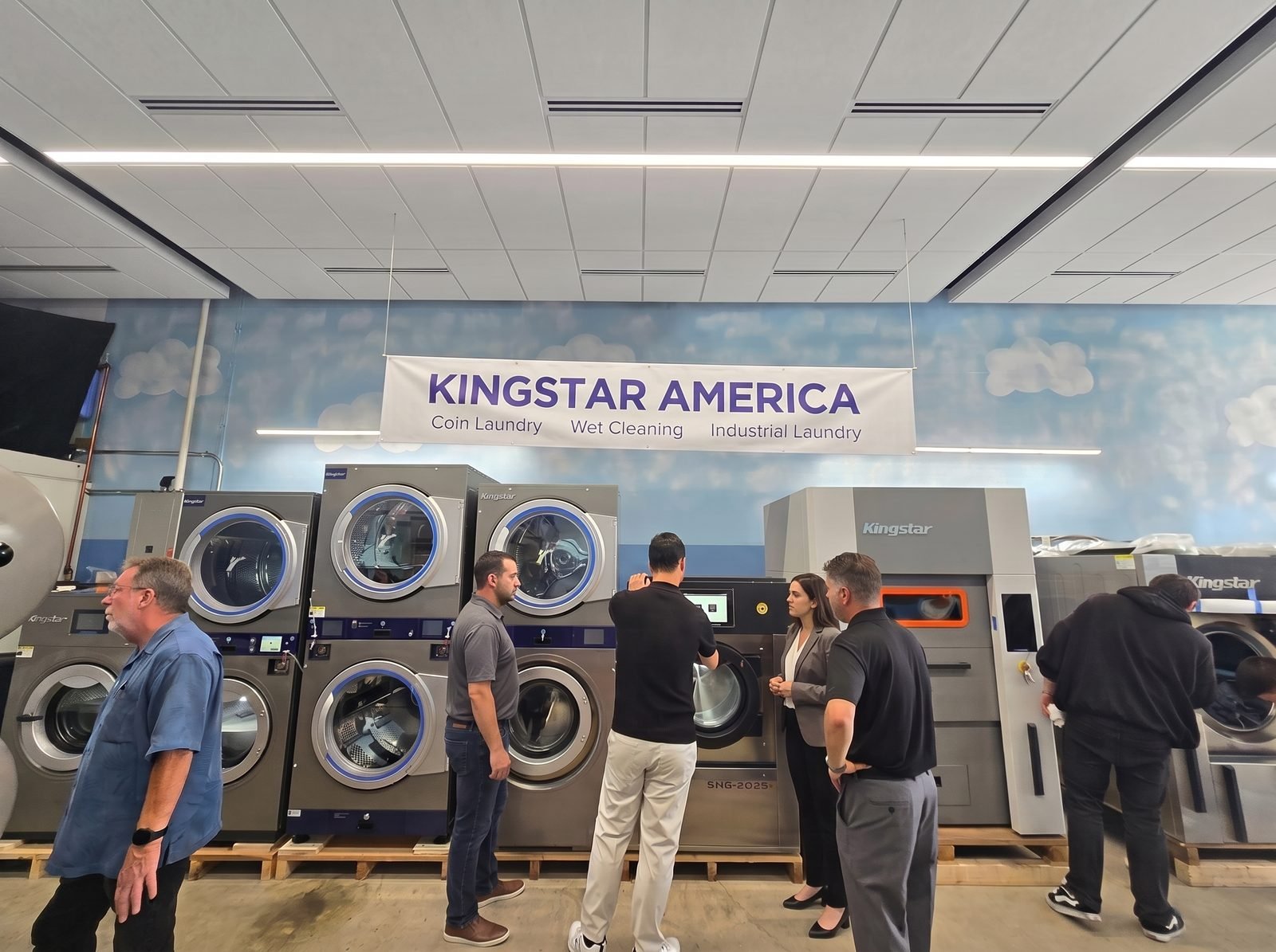 Customers touring industrial washers beneath the Kingstar America banner